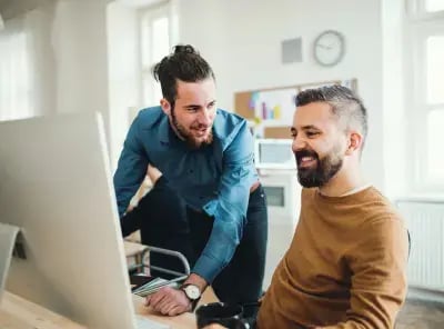 manager helping employee at his desk