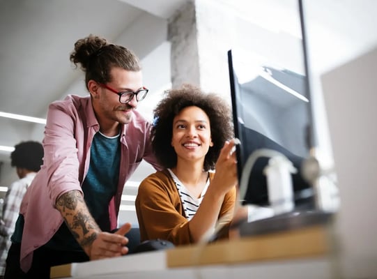 man and woman working at her desk in the office